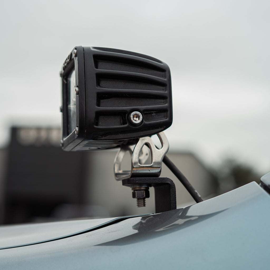 Cali Raised LED low profile bracket supporting a RIGID ditch light pod at the hood corner of a Lexus GX470