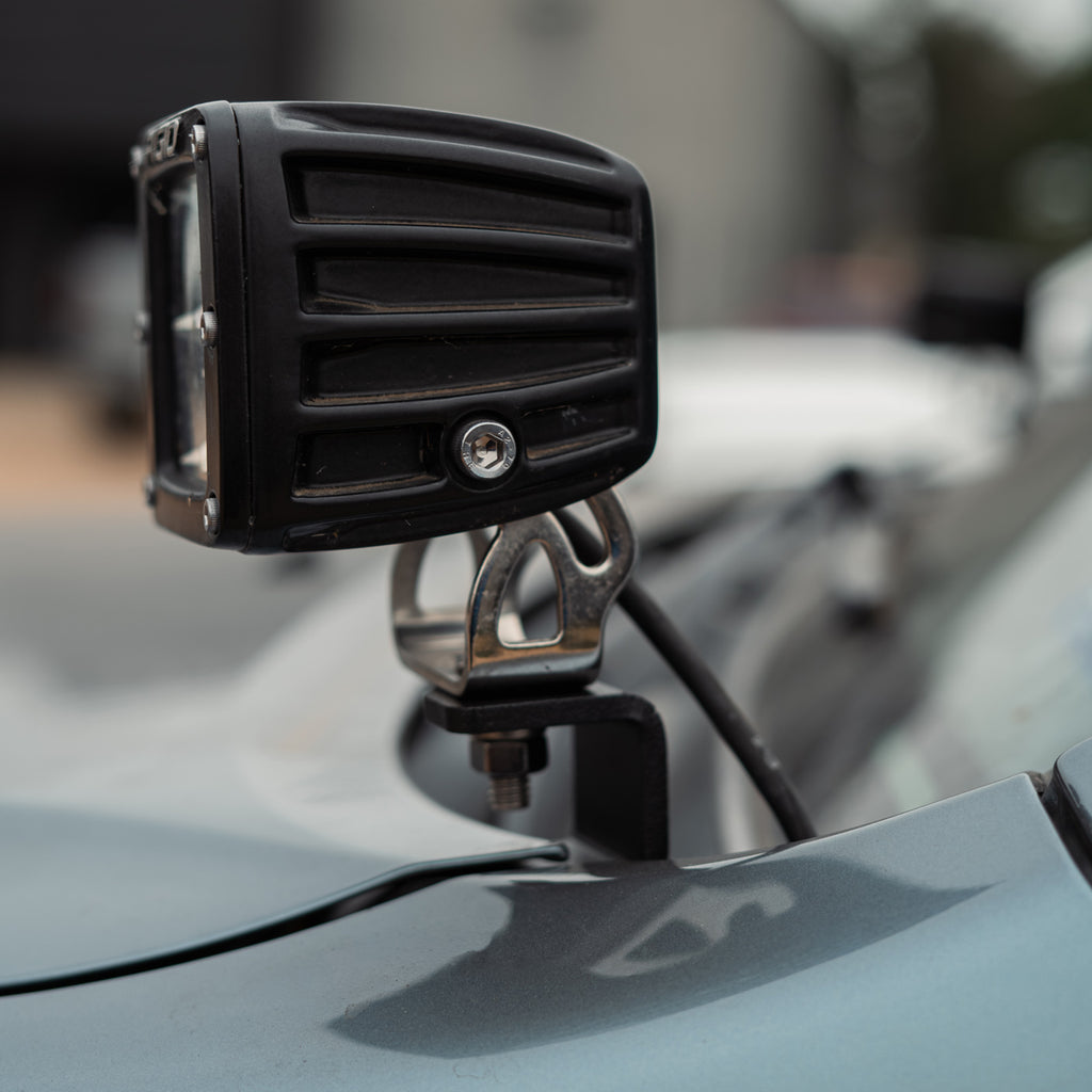 Close-up of the Lexus GX470 ditch light bracket with mounted RIGID pod and wiring beside the windshield
