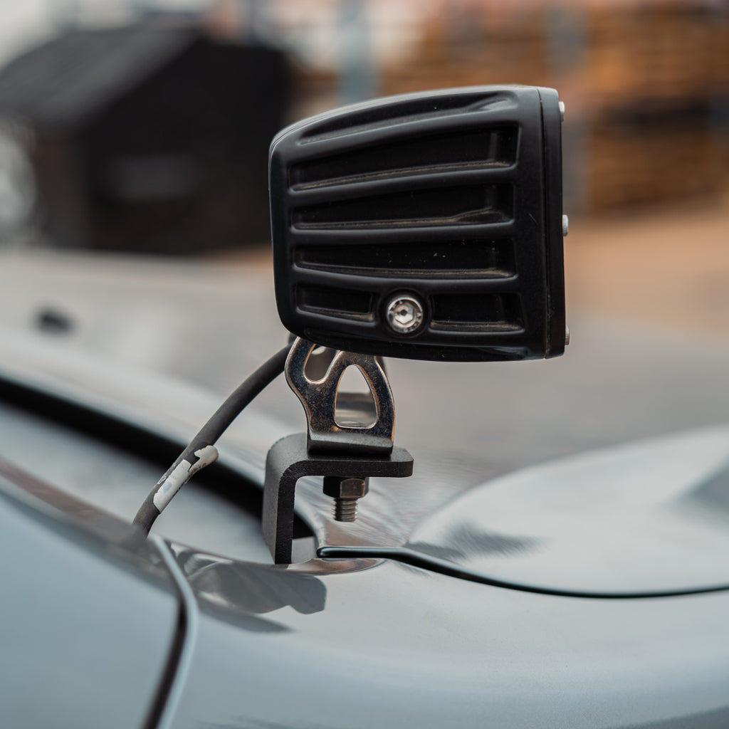 Rear view of a RIGID light pod on a black Cali Raised LED ditch light bracket installed on a Lexus GX470