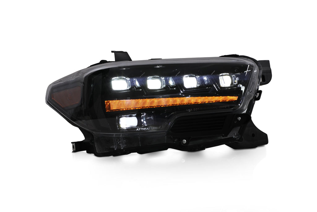 Attica Apex Series Tacoma headlight lit with projectors on and amber HammerGlow DRL bar