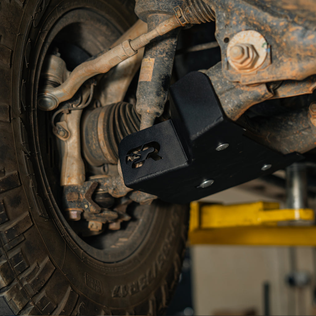 Powder-coated steel lower control arm skid plate protecting a 2025+ Toyota 4Runner
