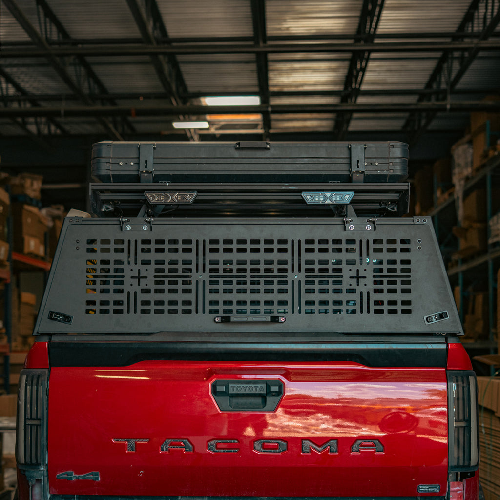 Rear hatch closed on a red Toyota Tacoma with the Cali Raised Overland Bed Rack