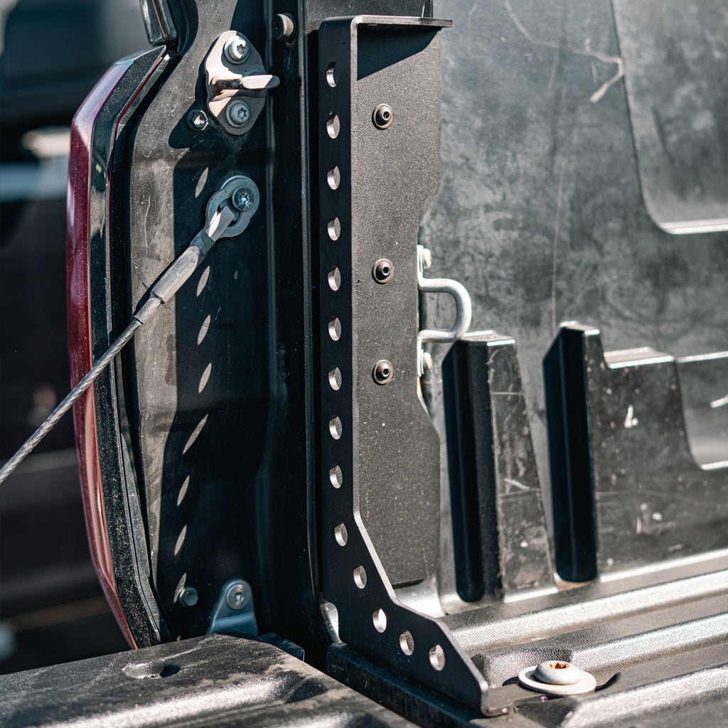 Cali Raised LED Tundra bed stiffener installed beside the tailgate, showing three side fasteners and the lower mount.