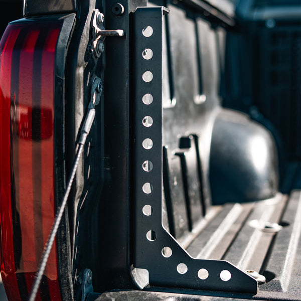 Close-up of the perforated Cali Raised LED Tundra bed support, showing its upright profile and lower reinforcing arm.