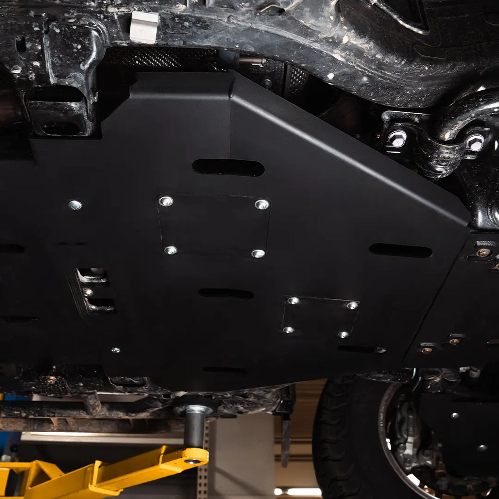 Cali Raised LED cat shield and transmission skid plate installed under a 2024+ Toyota Tacoma, black powder coat, both access doors on.